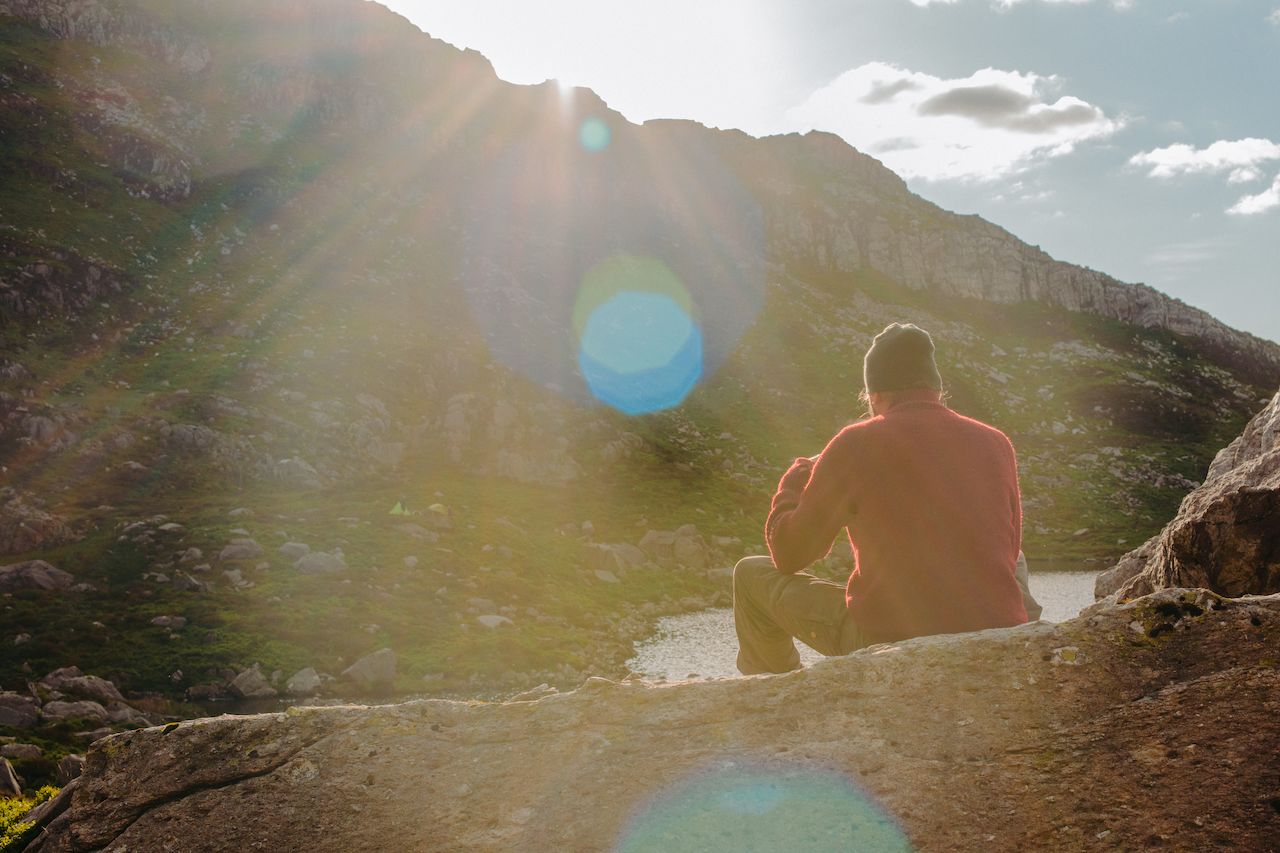 Klaas sitting on a rock watching the sun set
