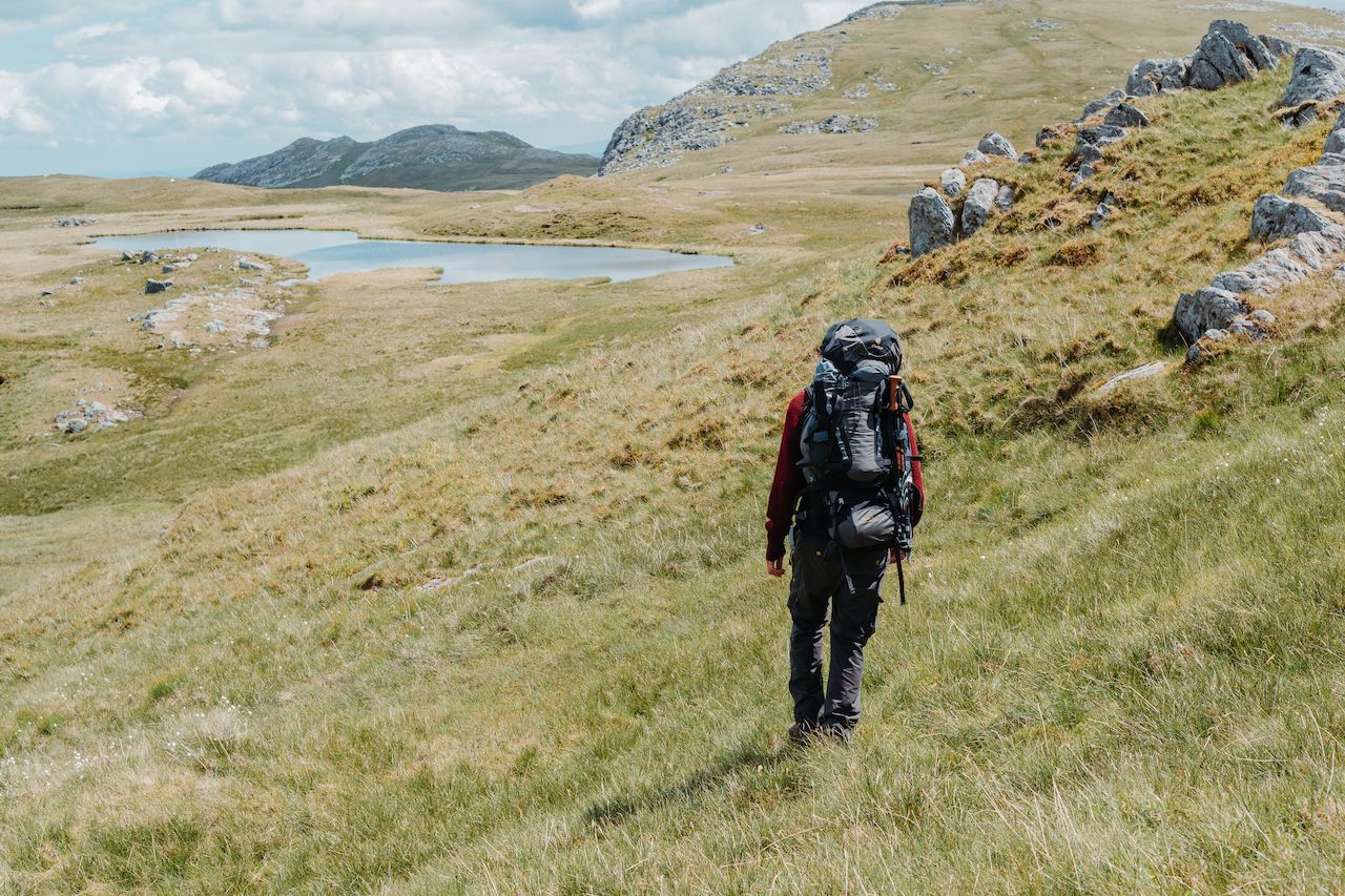 Klaas hiking through the fields towards a lake