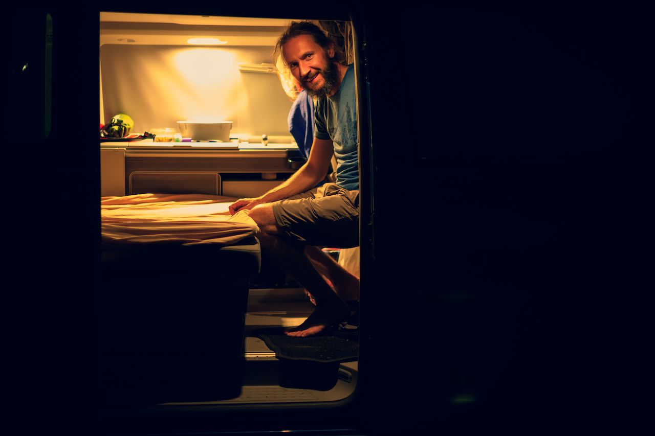 Klaas making the bed in his Volkswagen California