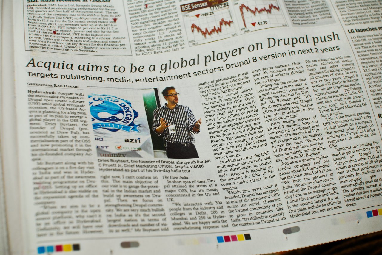 A newspaper article discusses Acquia's global expansion with a focus on Drupal, featuring a speaker at an event.