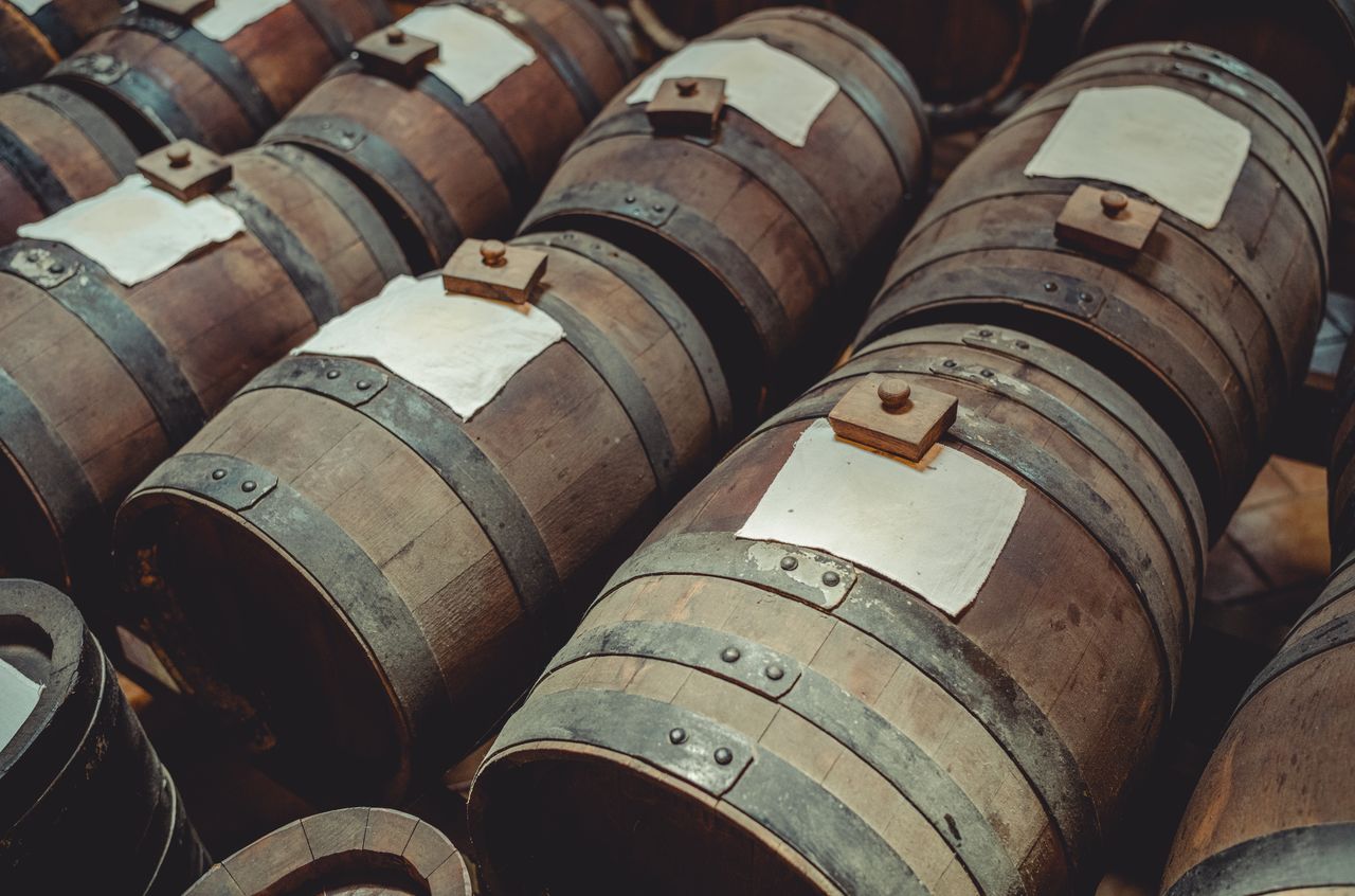 Rows of wooden barrels used for aging balsamic vinegar at Acetaia Leonardi, arranged in traditional "batteries.