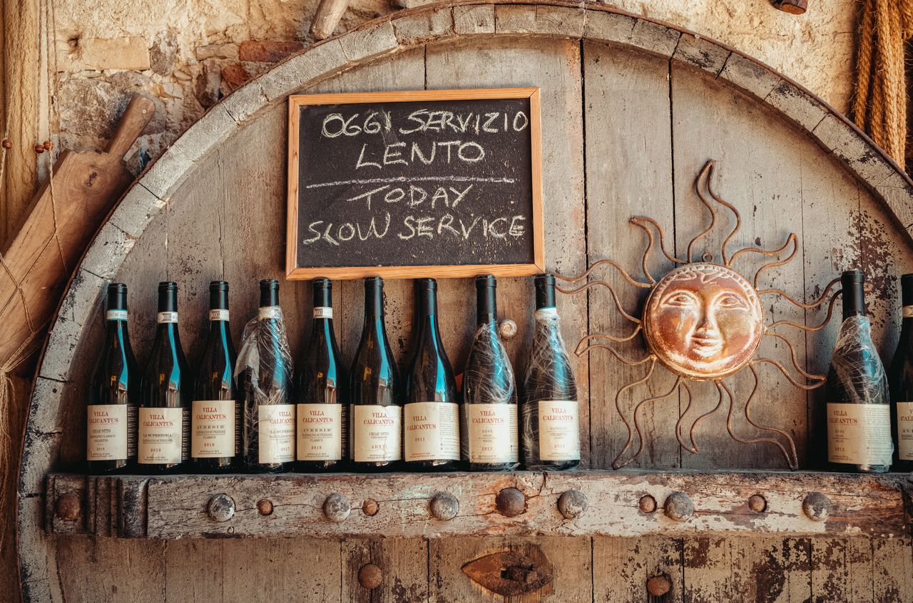 Old bottles of wine and a chalkboard with the text "Today slow service".