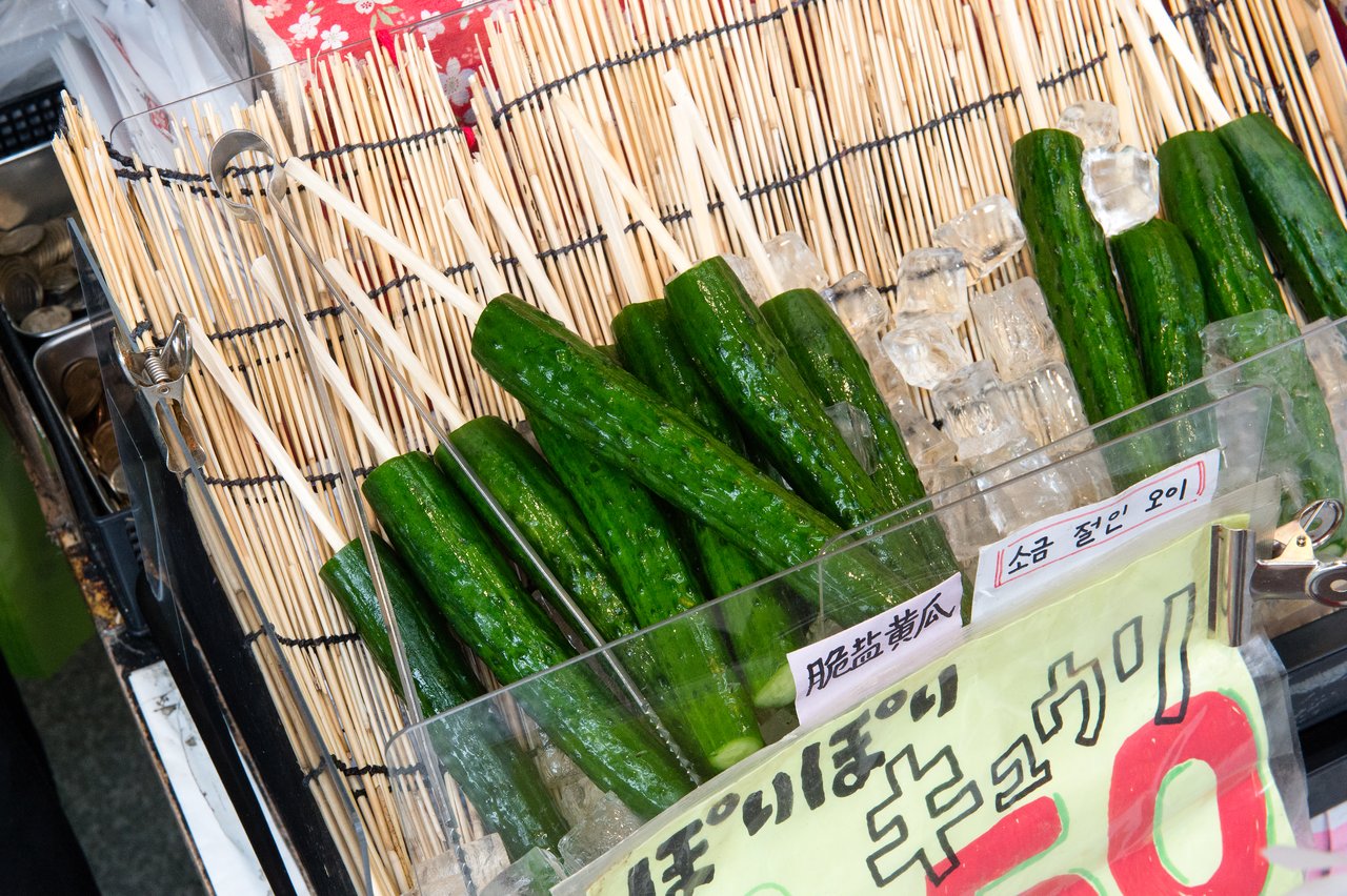 Skewered cucumbers on ice at a food stall in Japan, ready to be served as a refreshing snack.