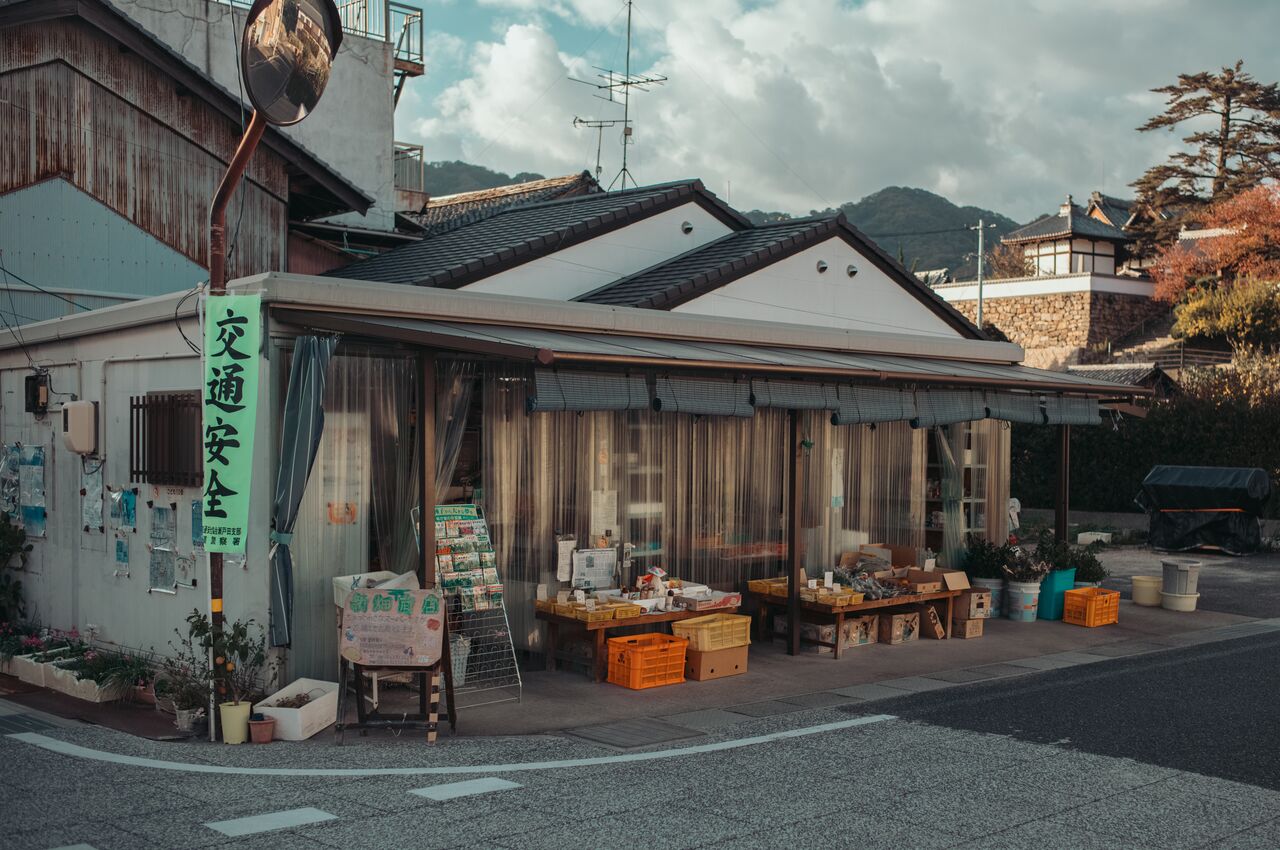 A small grocery store in Setoda with crates of produce and goods displayed outside under a canopy.