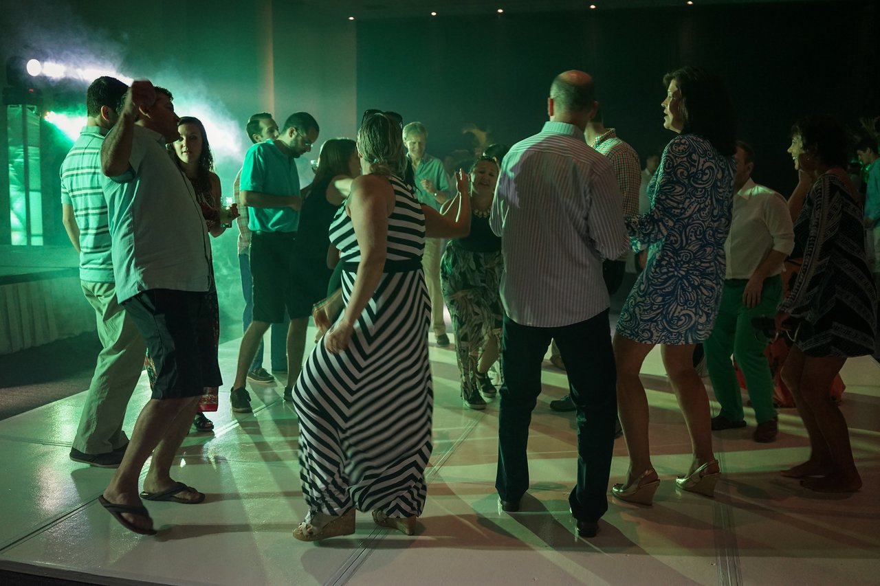 People dancing and celebrating at an award party, with colorful lights and a lively atmosphere.