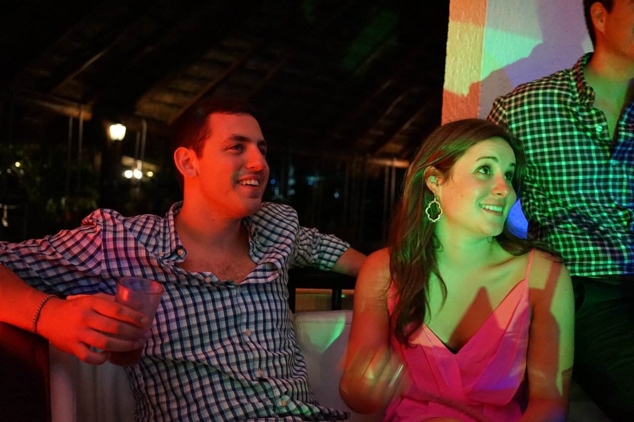 Two people sitting and smiling at an award party, engaged in conversation.