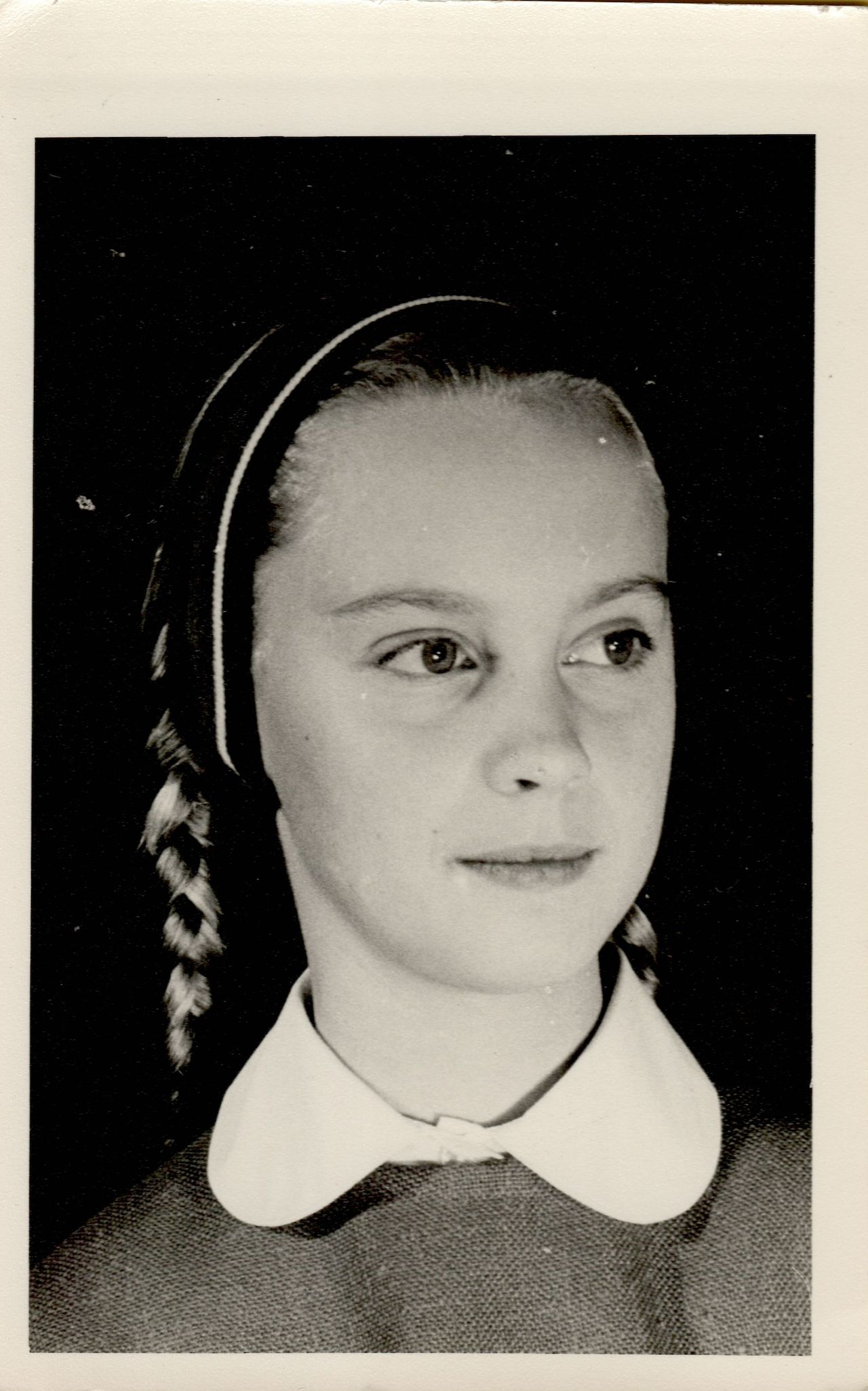 Black-and-white portrait of a young girl with braided hair, wearing a collared shirt, looking slightly to the side.