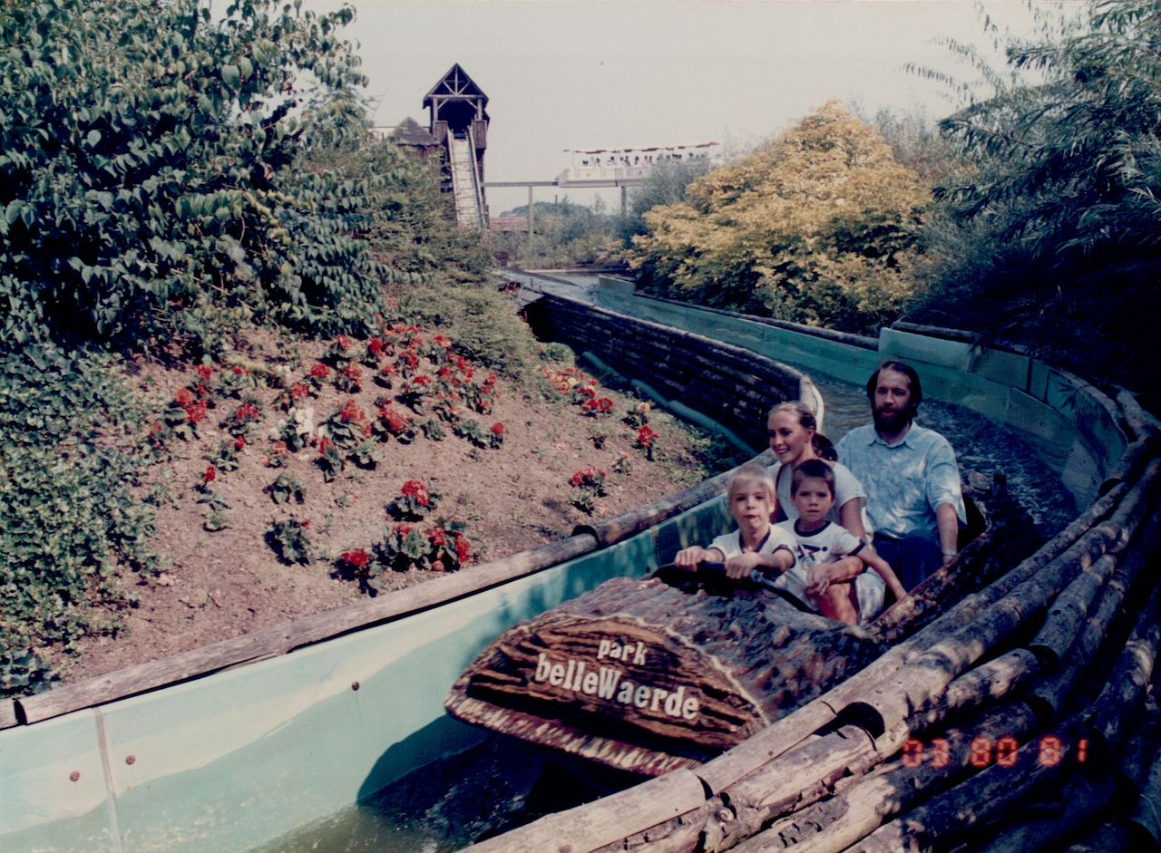 A family rides a log flume at Bellewaerde amusement park, with two children sitting in the front.