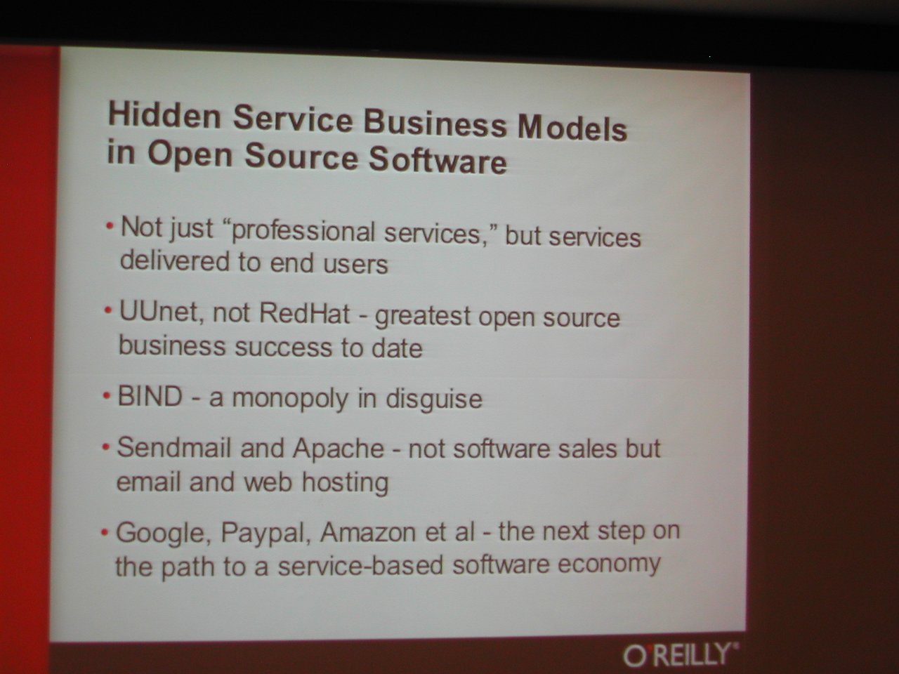 A presentation slide at FOSDEM 2004 discusses hidden service business models in open-source software, mentioning companies like Google and RedHat.
