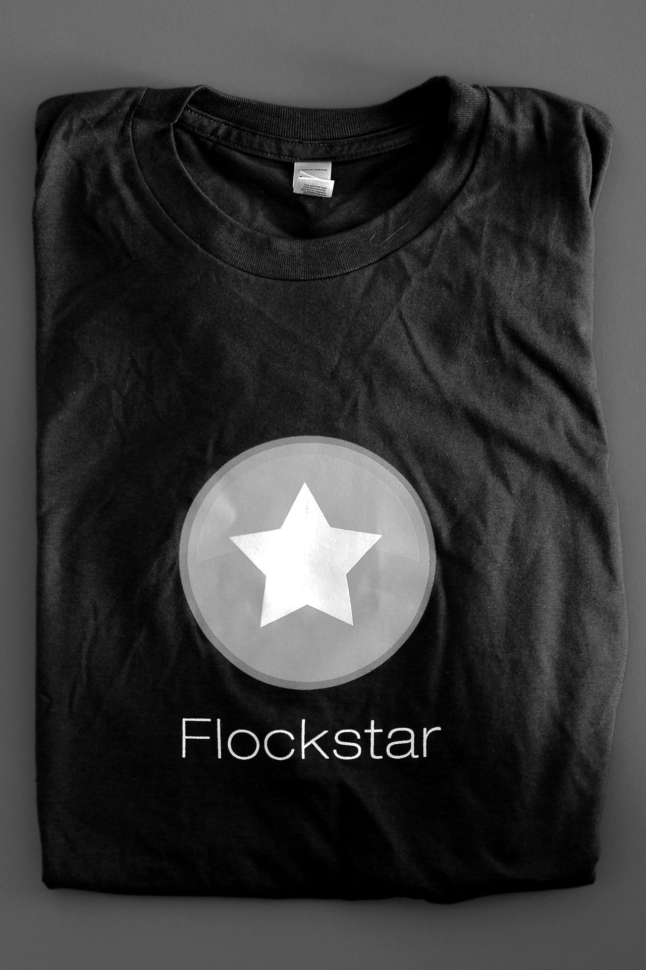 A black T-shirt with a white star inside a circle and the word "Flockstar" printed below.