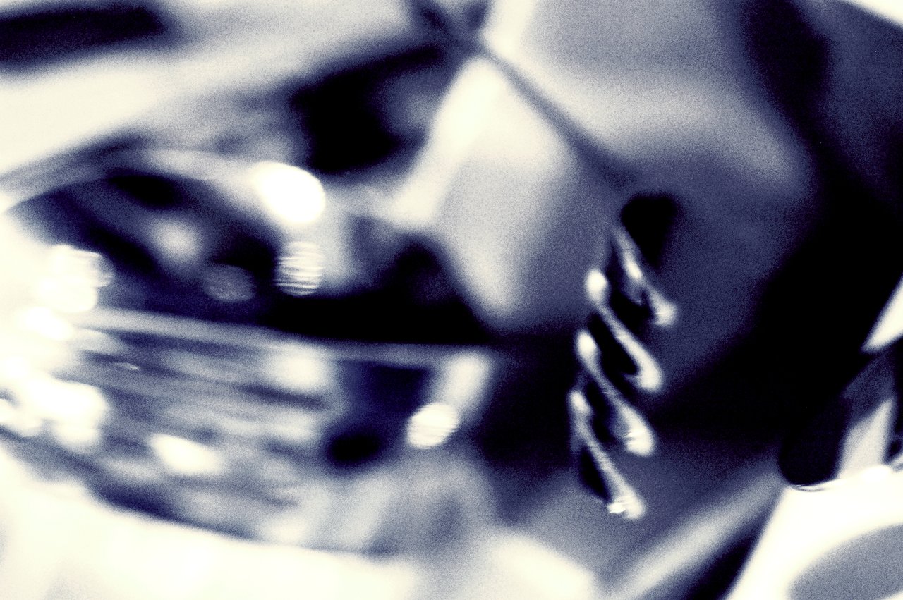 Close-up of a metallic fork with a blurred background, captured in high contrast and blue-toned lighting.