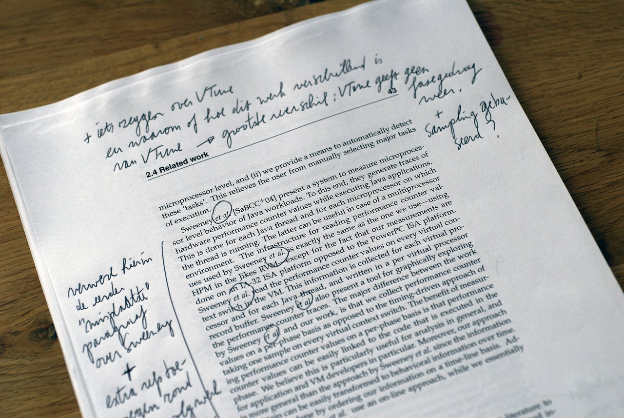 A printed academic paper with handwritten feedback and corrections from an advisor, including circled text and margin notes.