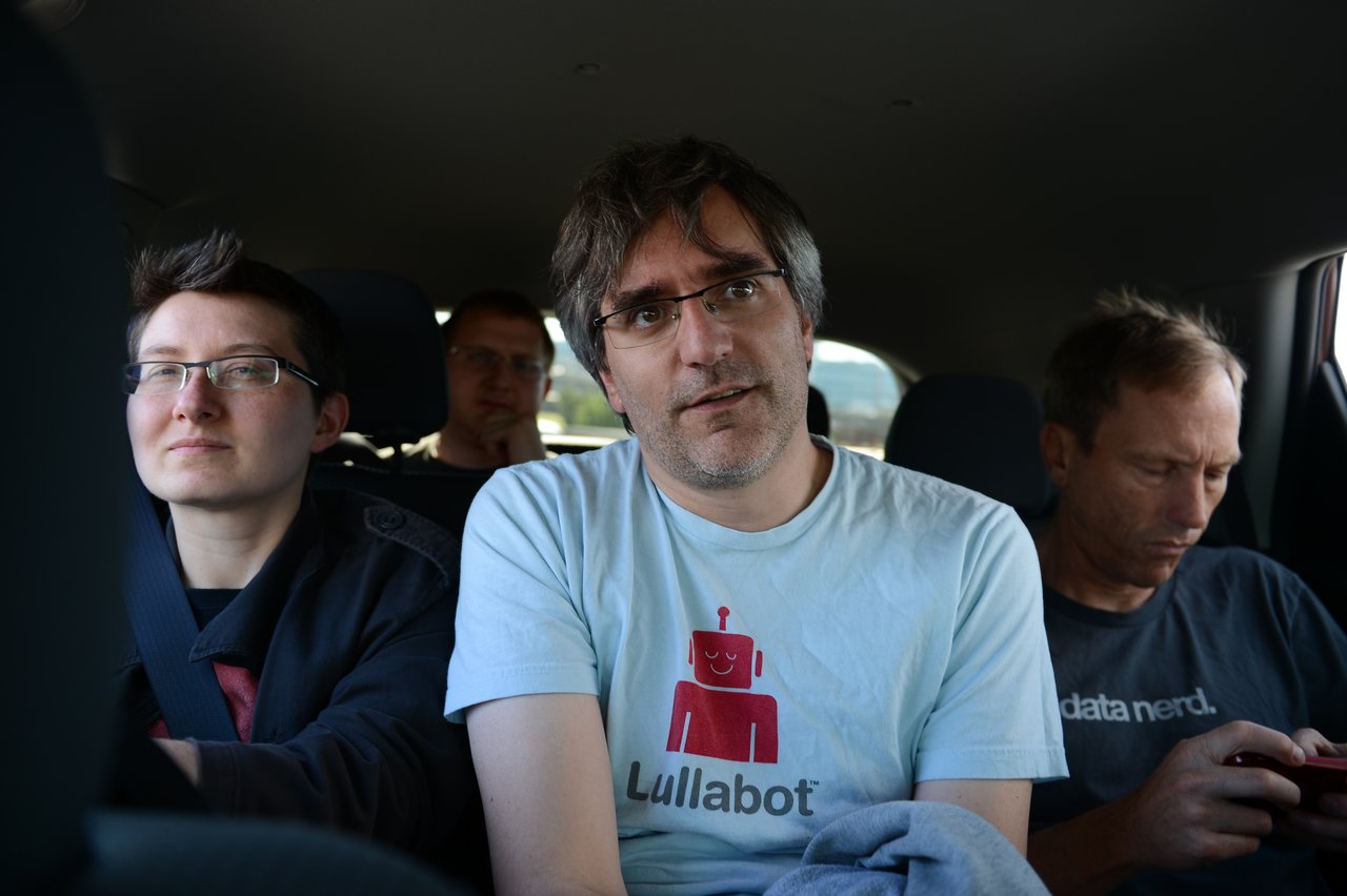 Four people sitting in a car, with one person in a "Lullabot" shirt looking at the camera.