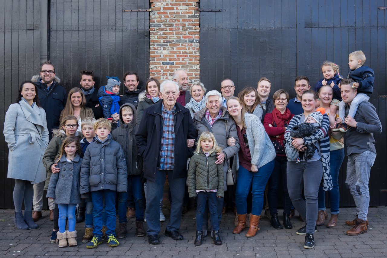 A large family gathers outdoors for a group photo, celebrating a grandmother's ninetieth birthday.
