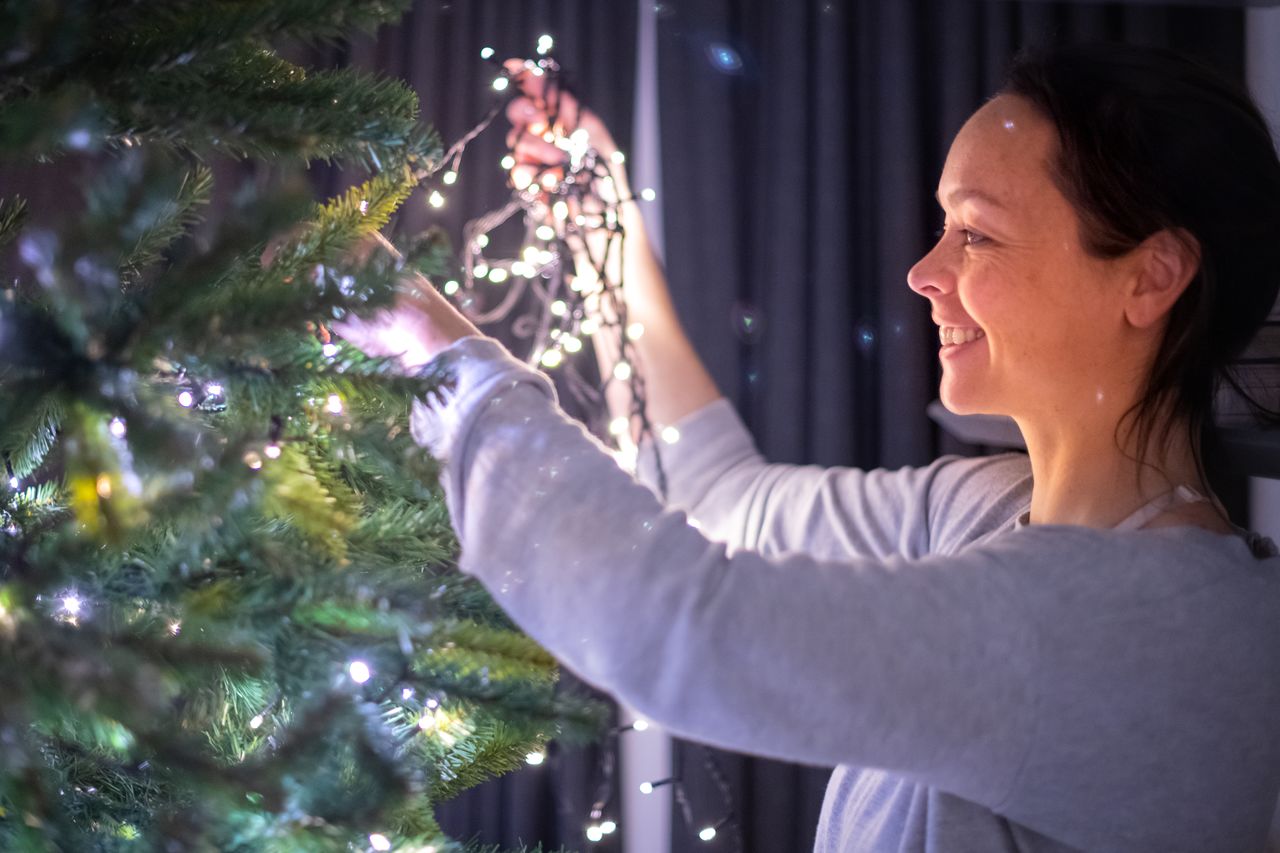 Vanessa hanging the lights in the Christmas tree