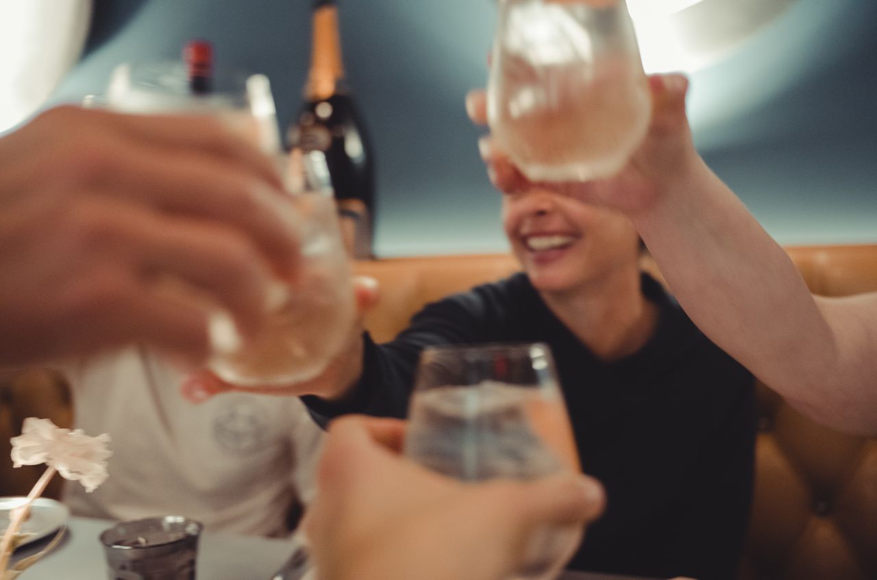 People drinking cocktails and toasting.