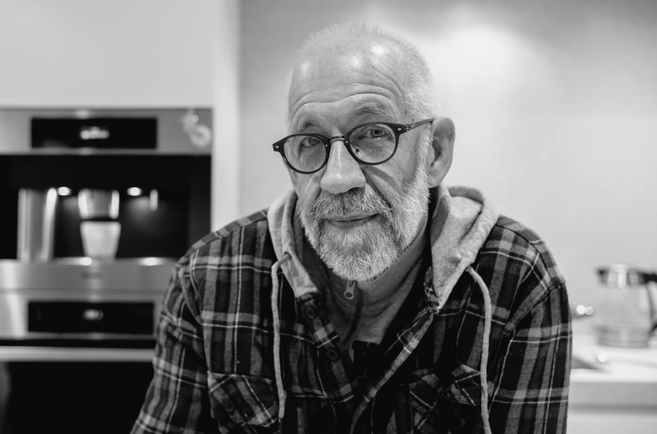 A portrait of a man with a beard and glasses.
