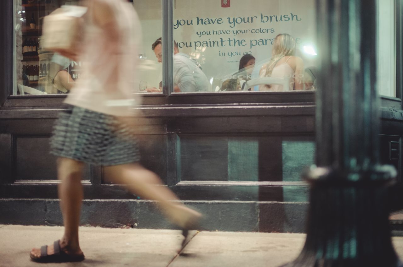 A person walking down the street with a box in their hand.