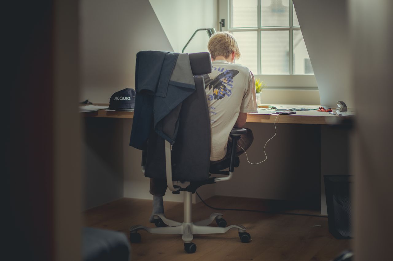 A young man sitting at a desk, focused on studying.