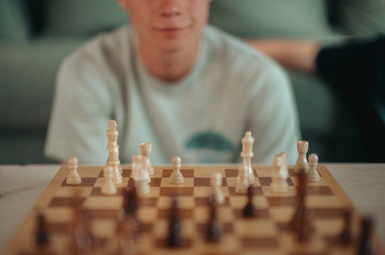 A person playing a chess game at a table.