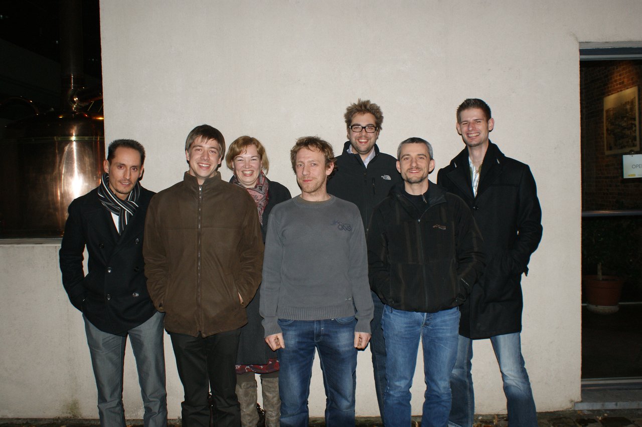 A group of seven people stands together outside, smiling at the camera during a planning event.