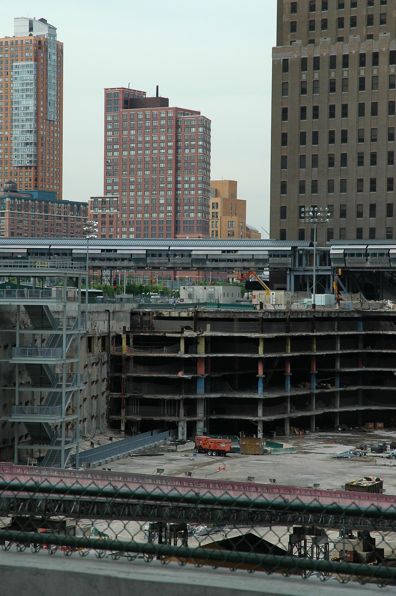 Partially demolished building at Ground Zero with construction equipment and fencing in the foreground.