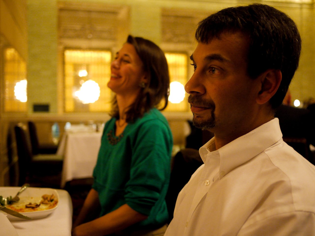 Two people sitting at a table during a Drupal Association meeting, one smiling and the other looking thoughtful.