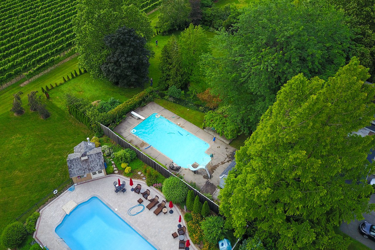 Aerial view of two swimming pools with lounge chairs and umbrellas.