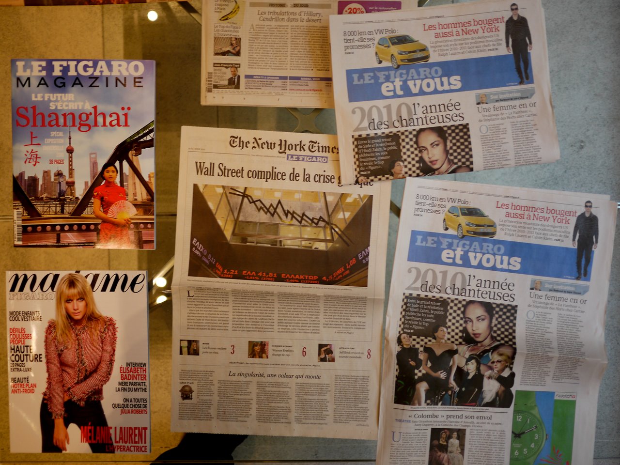 Several Le Figaro print publications displayed on a table, including an issue featuring The New York Times translation.