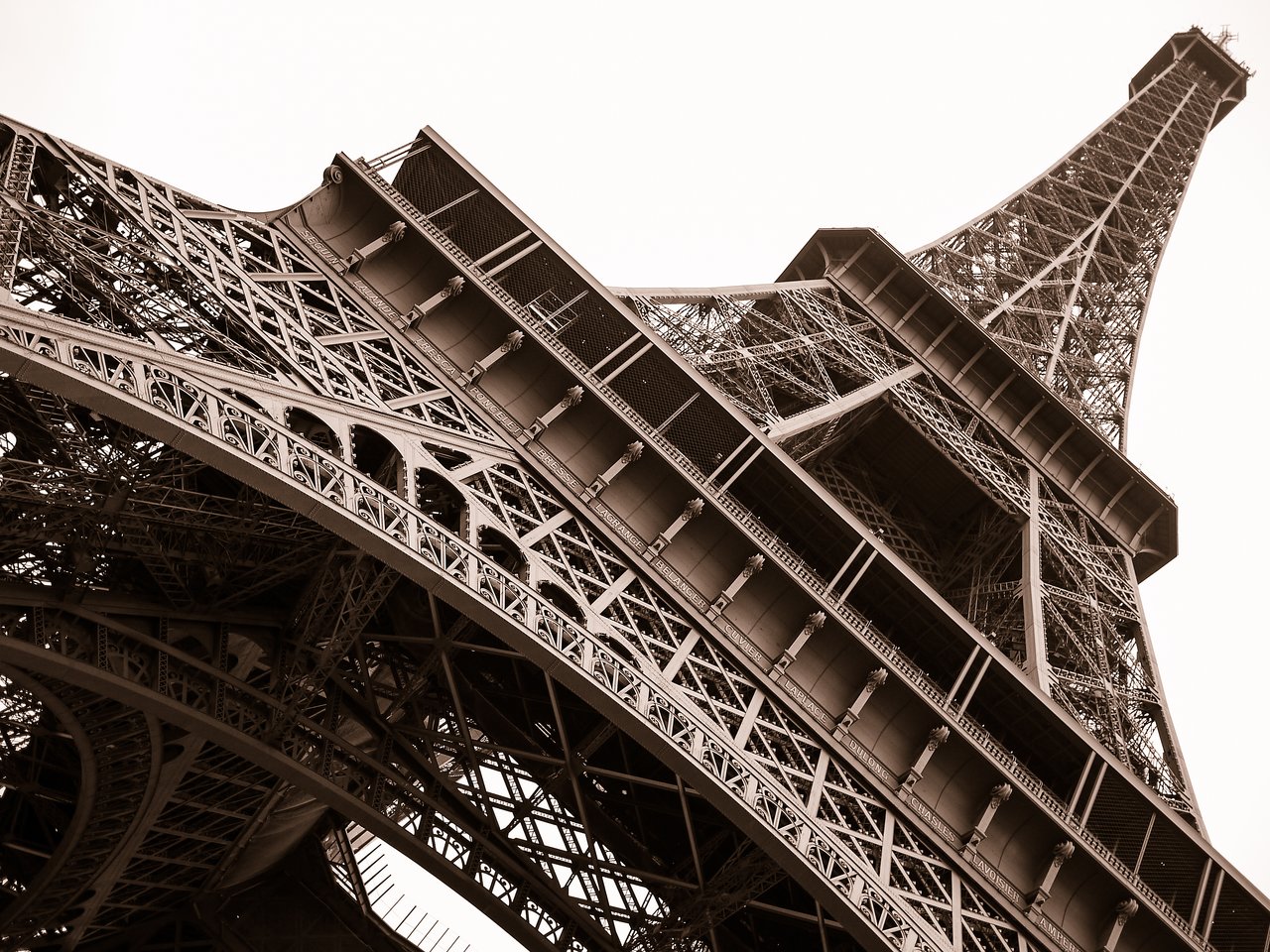 Low-angle view of the Eiffel Tower, showing its intricate metal structure and design.