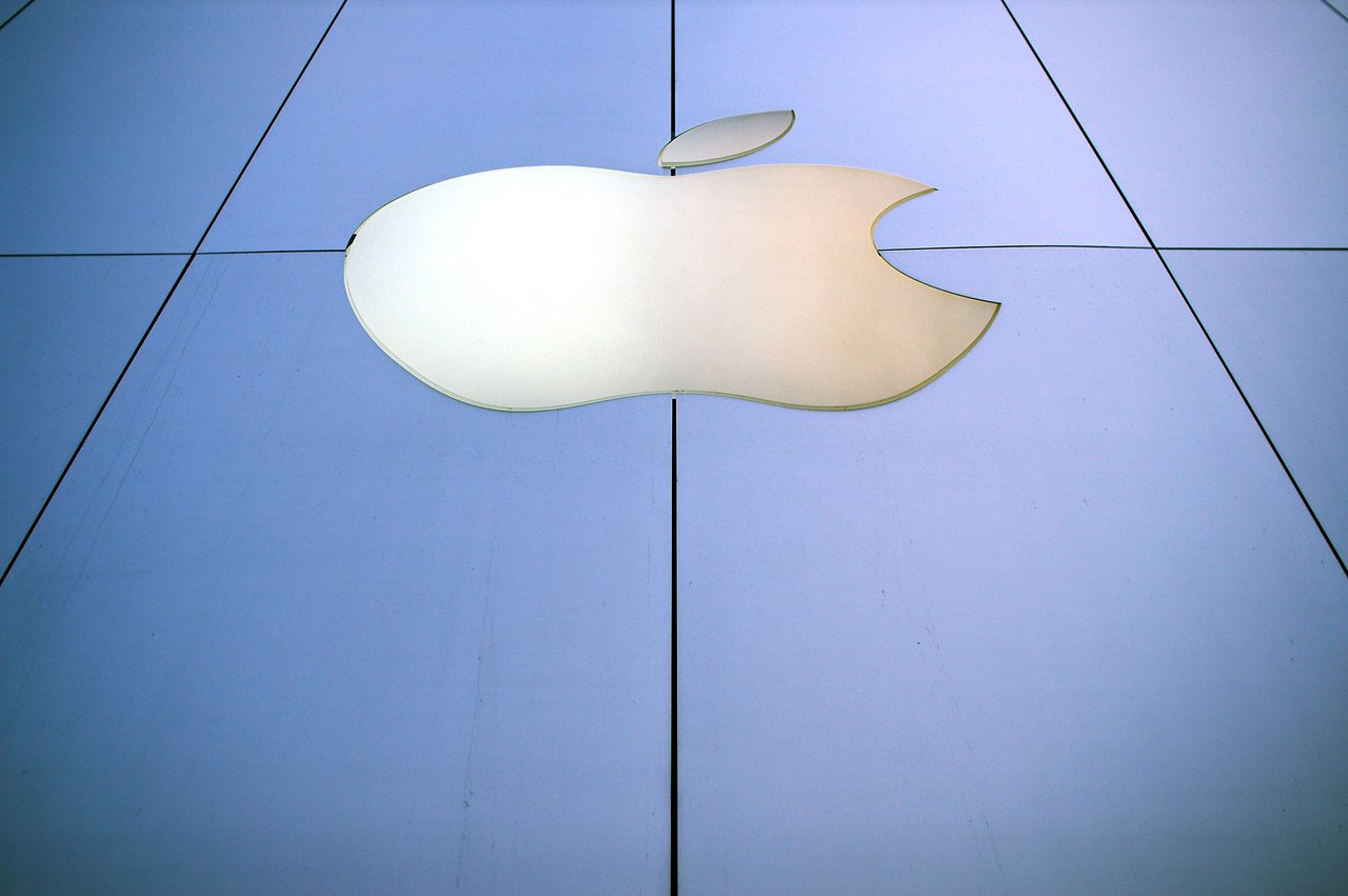 Large Apple logo on the exterior of an Apple Store in San Francisco, viewed from a low angle.