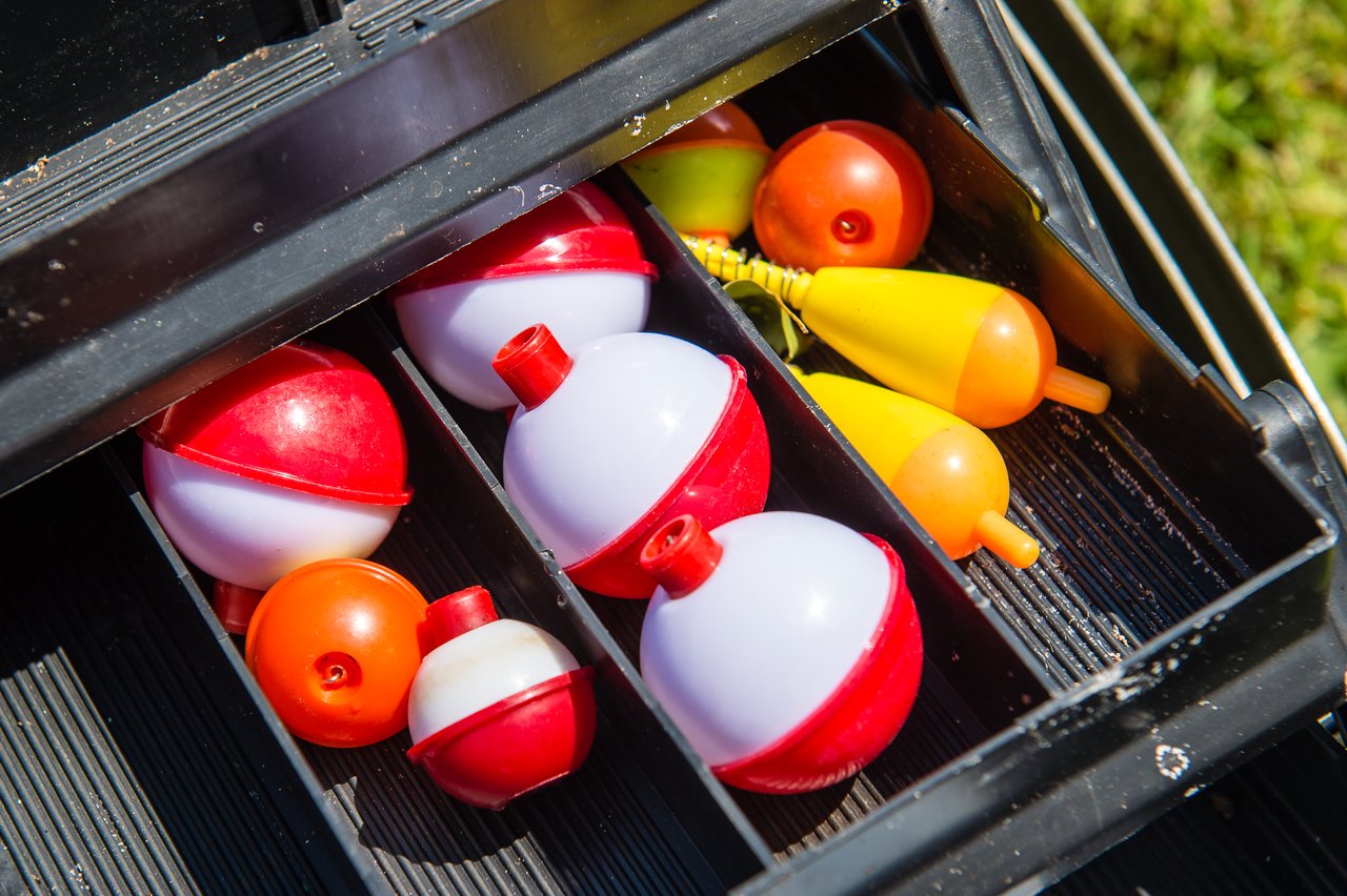 A tackle box filled with colorful fishing bobbers and floats, ready for a fishing trip.