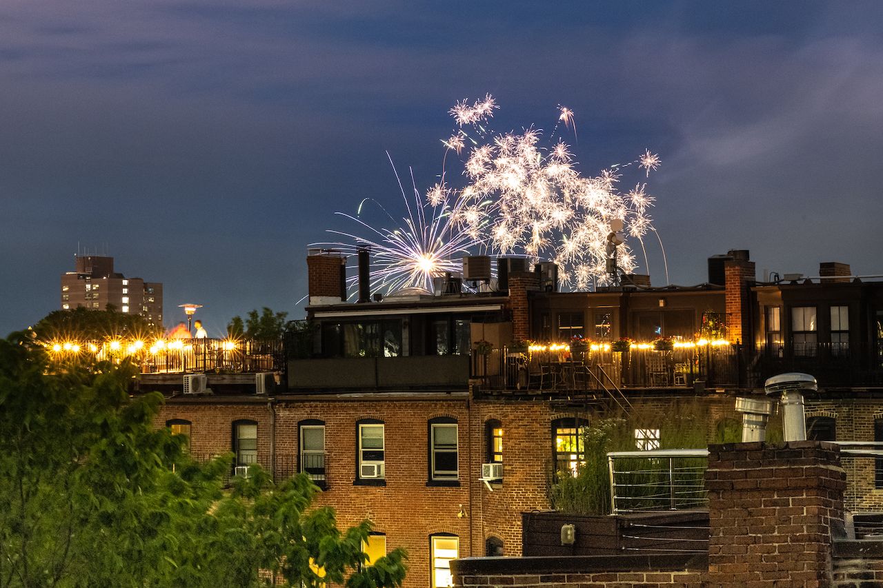 Fireworks light up the night sky above city rooftops during a 4th of July celebration in Boston.
