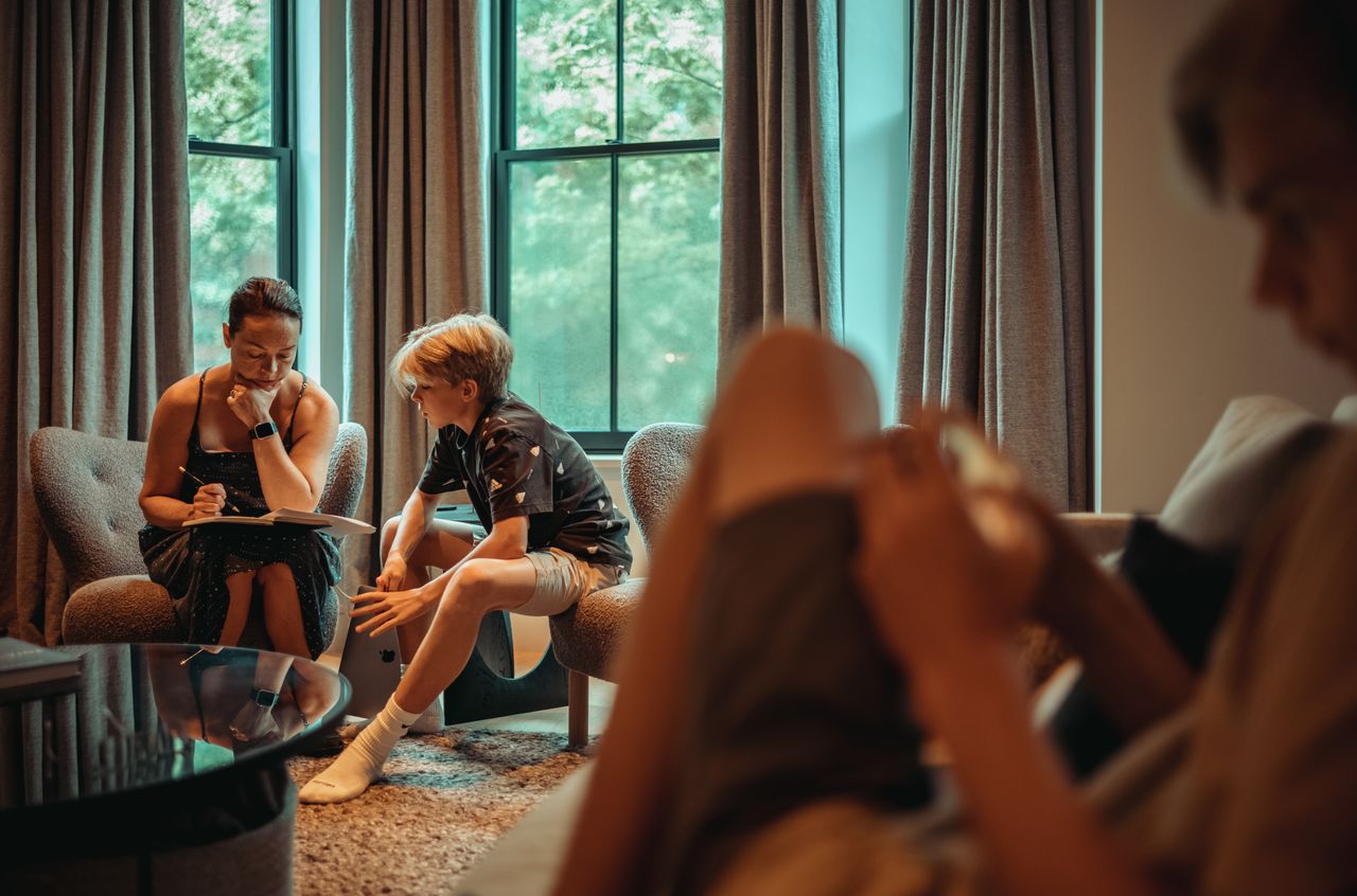 Vanessa and Stan working on math exercises together in a cozy room with large windows.