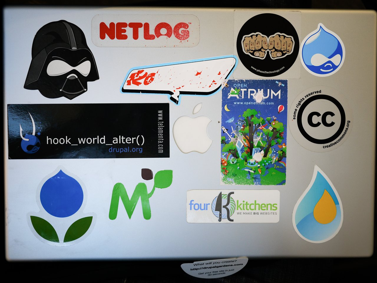 A laptop covered in colorful stickers is drying.