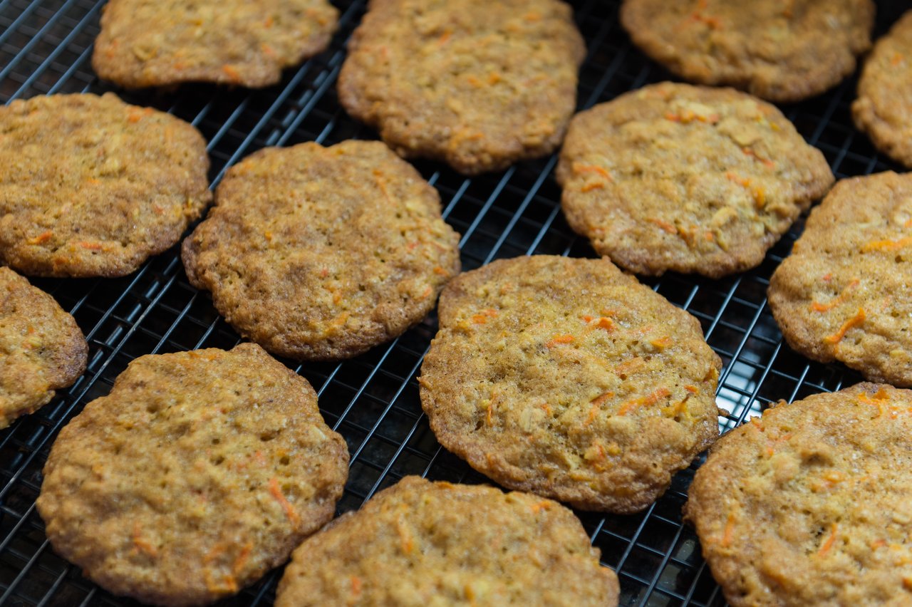 Freshly baked carrot cake cookies cooling on a wire rack.
