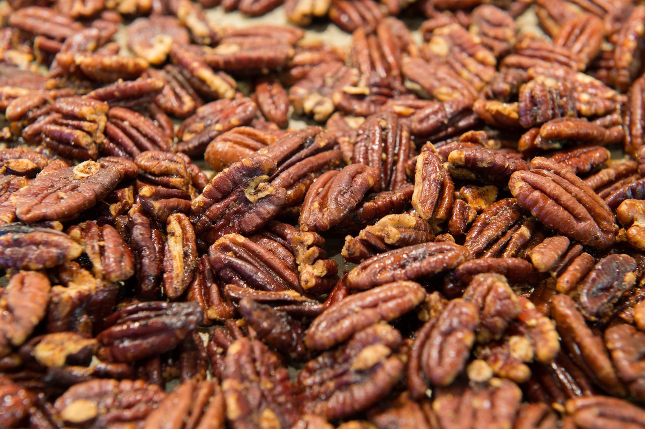 Close-up of spiced pecans, roasted to a golden brown with a seasoning coating.