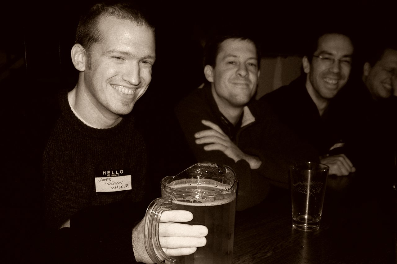 Three men sitting at a table, smiling.