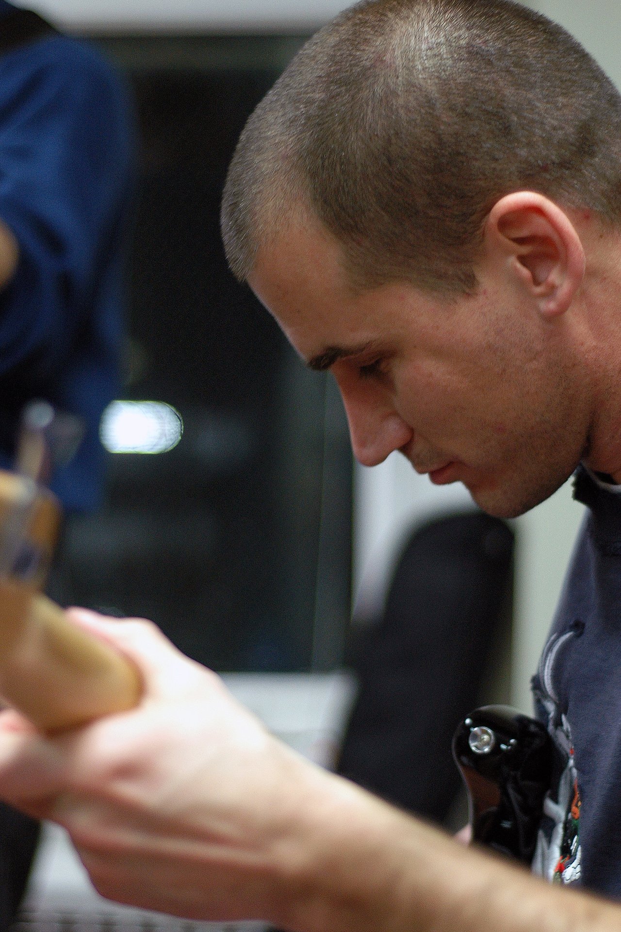 A person playing an electric guitar, focusing intently on the instrument.