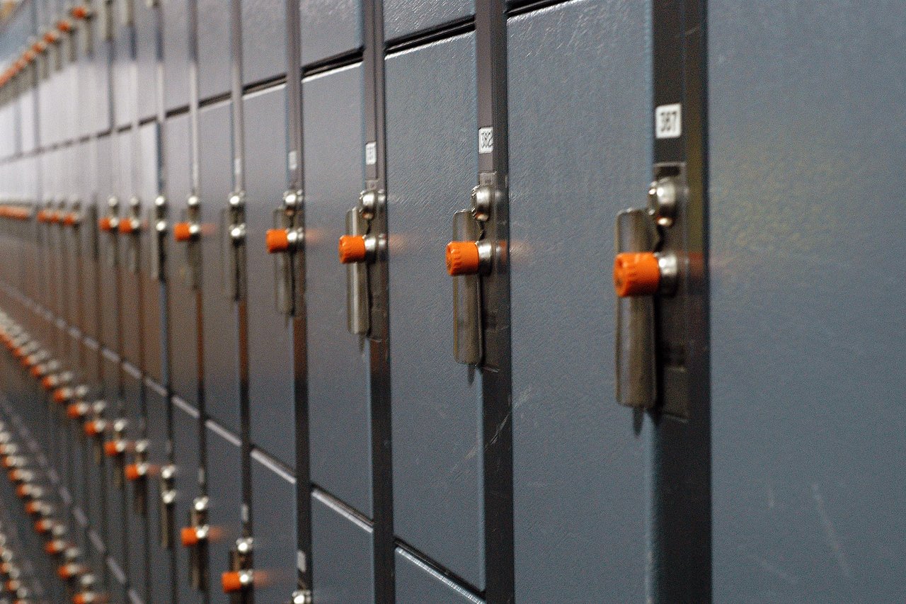 A row of gray lockers with metal locks and orange knobs at Cypress Mountain.