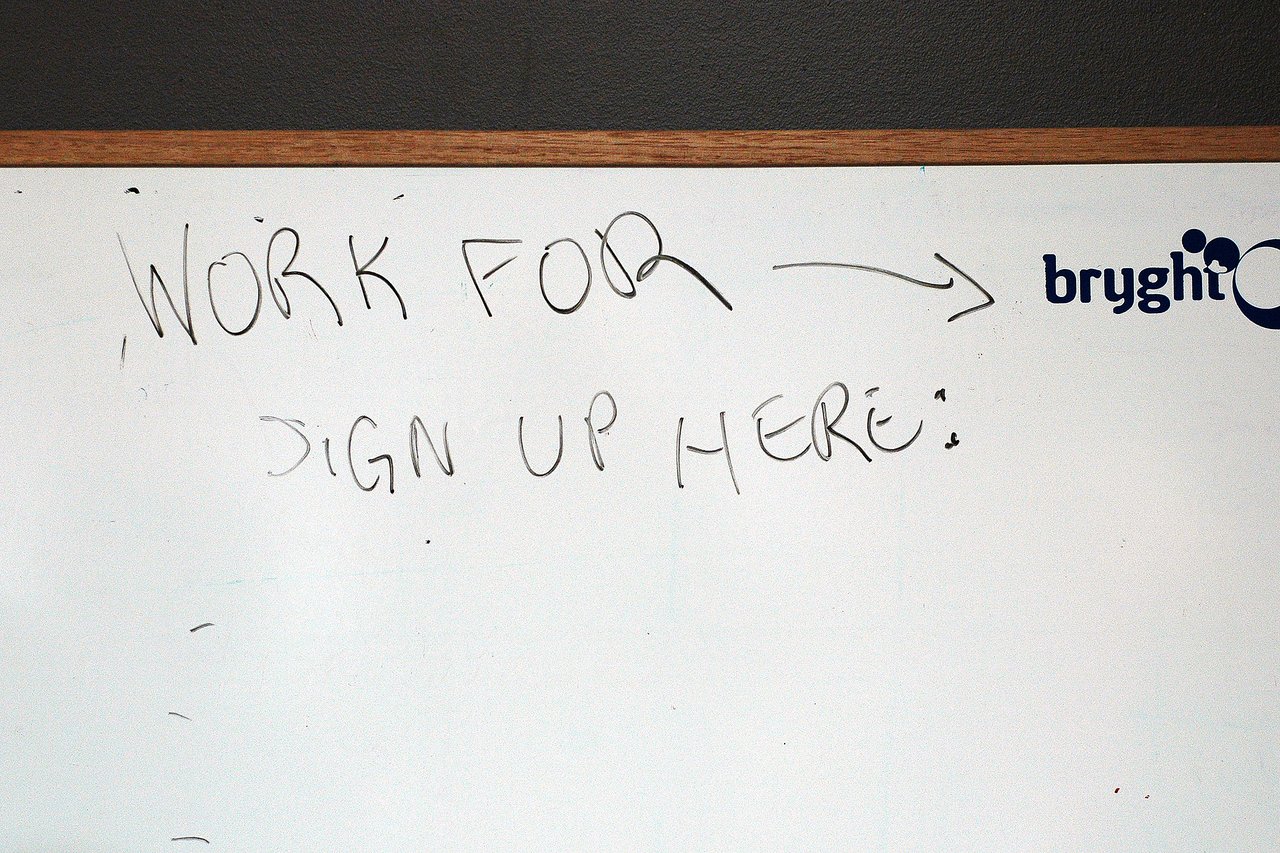 A whiteboard with handwritten text saying "Work for Bryght: sign up here".