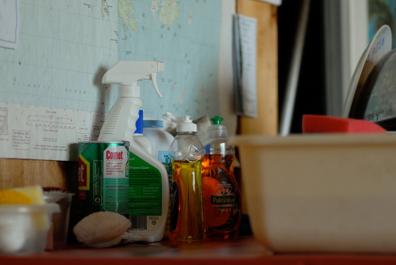 Dishwashing supplies, including soap, sponges, and a plastic basin, set up for washing dishes without running water.