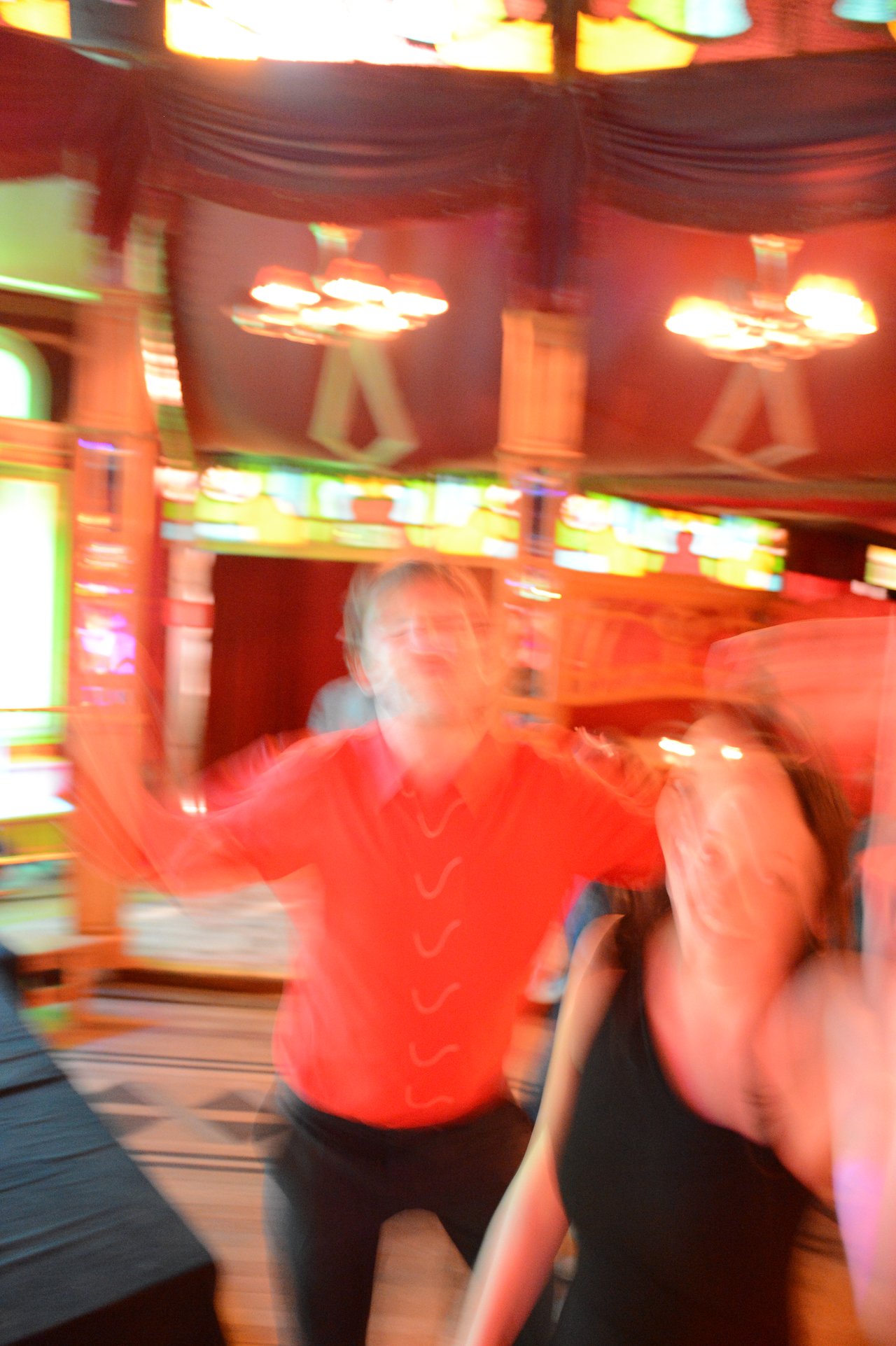 Two people dancing at a wedding reception, with motion blur making their faces and movements unclear.