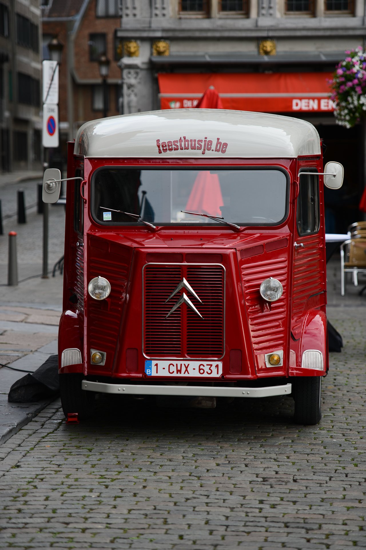 A vintage red Citroën van with "feestbusje.
