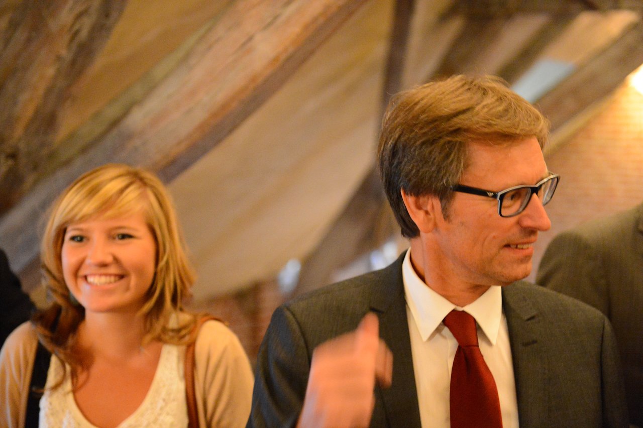 A man in a suit and a woman smiling at a wedding reception.
