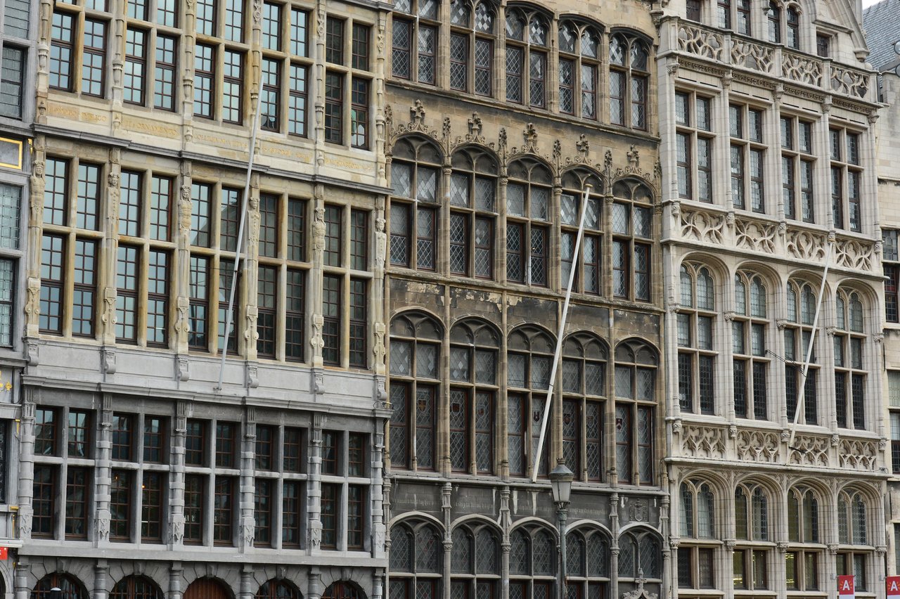 A row of historic buildings with large windows and decorative facades in a European city.