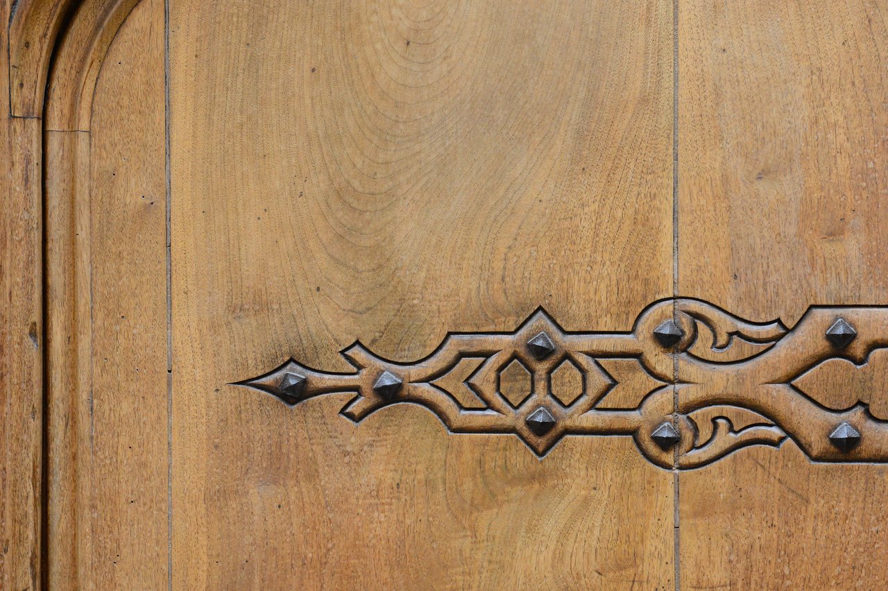 A close-up of a wooden door with decorative metal hinges, possibly part of a wedding venue entrance.