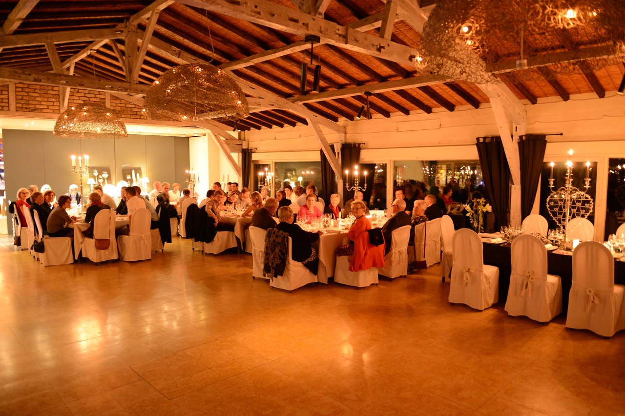 Guests seated at decorated tables during a wedding reception, engaged in conversation and enjoying the celebration.