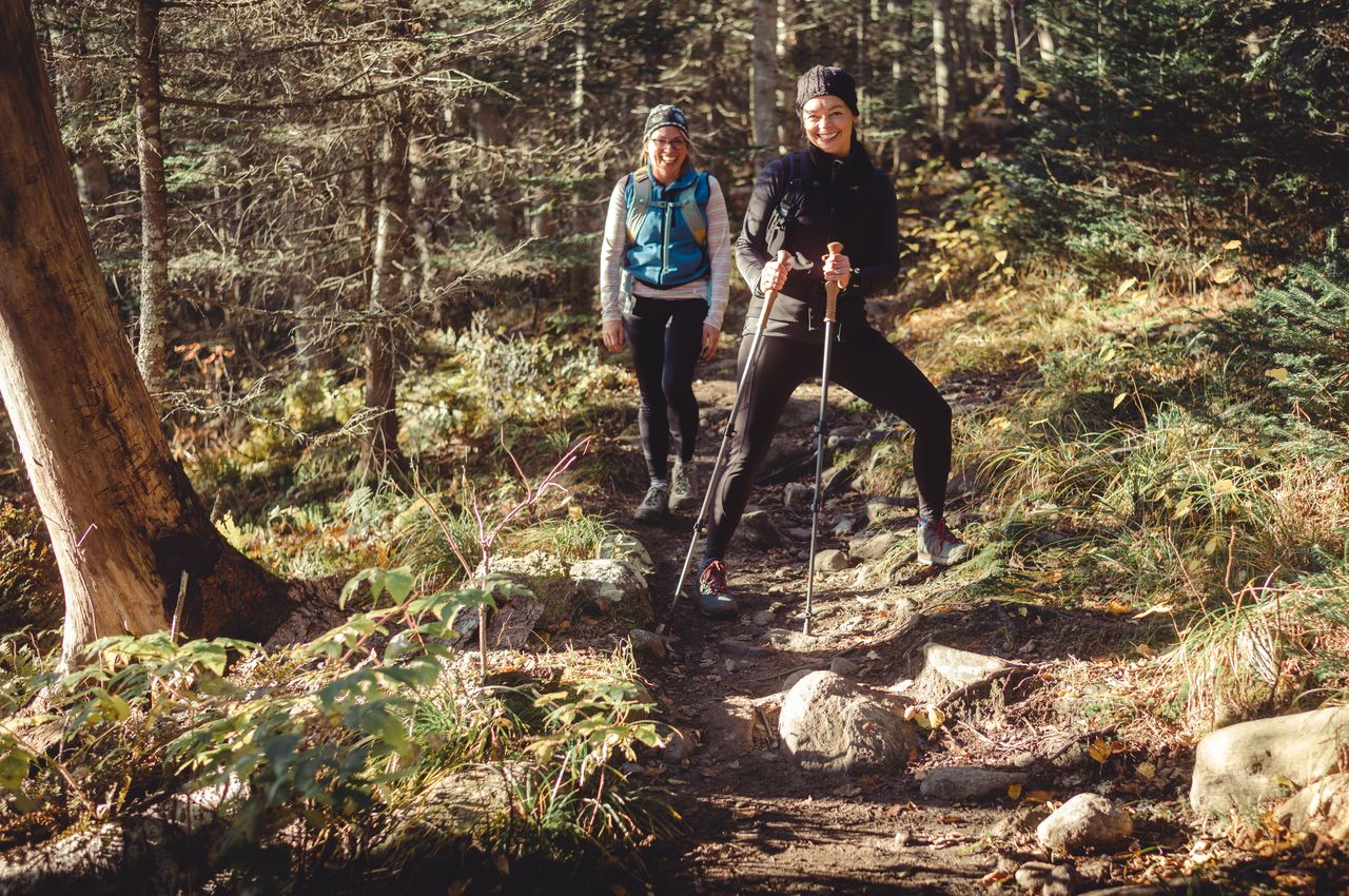 Two women on a hiking trail laughing.