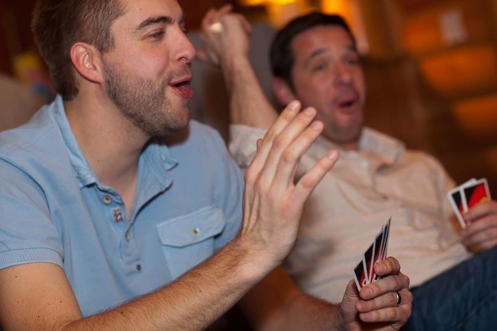 Two people playing a card game, reacting with excitement.